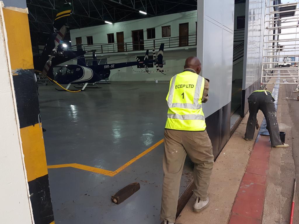 ECEP Ltd worker in branded safety vest finishing works inside a helicopter hangar